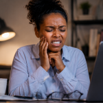 Person clenching jaw from stress showing signs of bruxism and teeth grinding in Nairobi CBD