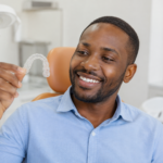Adult braces Nairobi patient smiling with clear aligners at a dental clinic.